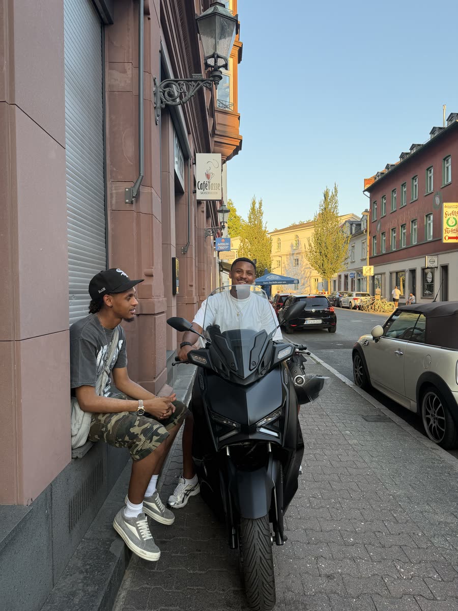 Hanging out on the street next to a scooter